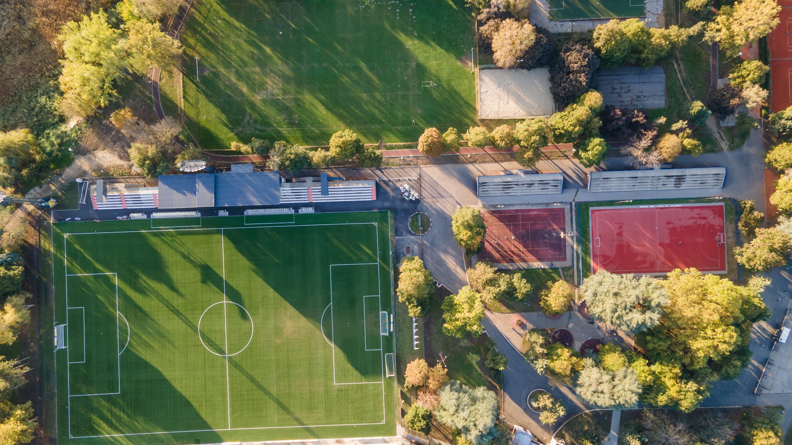 Soccer field with goal and penalty area from above. Overhead view of the penalty area of a football pitch with synthetic grass. No people. Sunset background texture